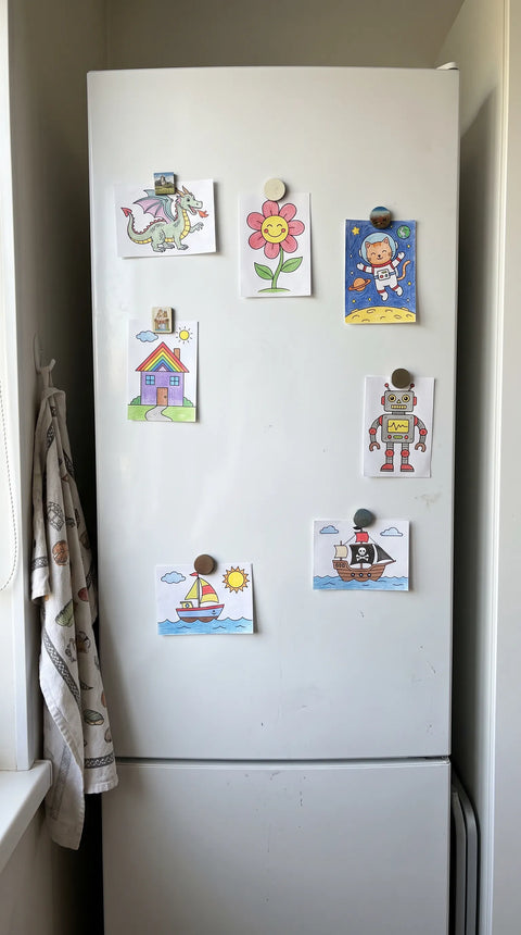 Ein Kühlschrank ist mit kleinen bunten Tier-, Blumen- und Weltraummotiven geschmückt.